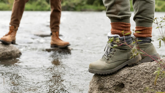 Couple wearing waterproof boots standing on rocks