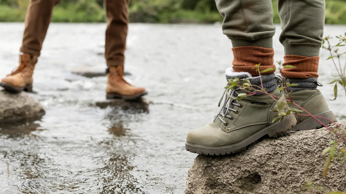 Couple wearing waterproof boots standing on rocks